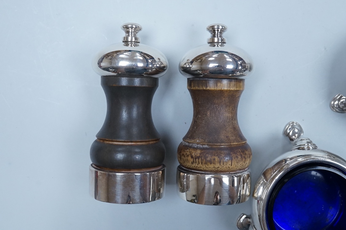 Two modern silver mounted pepper mills, 10.5cm, one other silver pepper mill by Hukin & Heath, Birmingham, 1926 and a pair of George III silver bun shaped salts, David Hennell I, London, 1750, with blue glass liners.